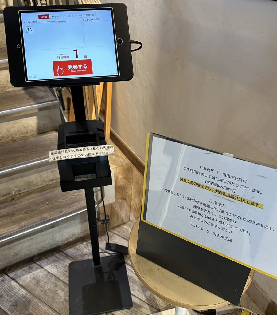 階段途中の2階に発券機があるので、人数や、テーブルかカウンターかを選択して、発券します。