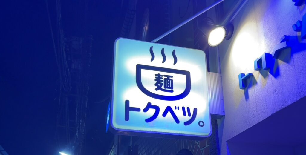 青いライトに看板が趣深い外観